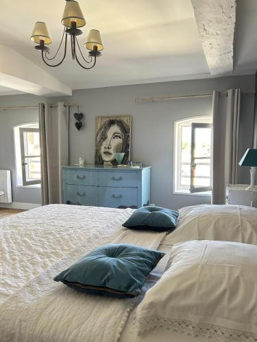 une chambre avec un grand lit avec deux oreillers dessus dans l'établissement Le Jardin des Anges, à Saint-Jean-dʼAngély