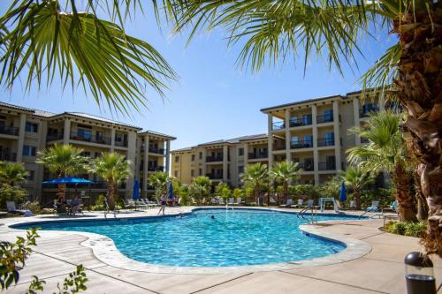 una piscina con palmeras y edificios en EXPERIENCE Estancia Amenity Filled Resort, en St. George