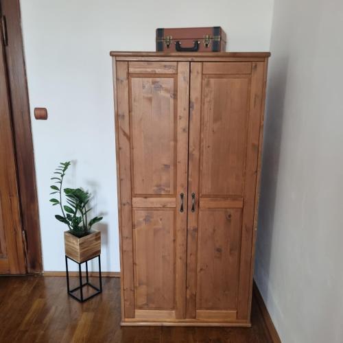 a wooden cabinet with a suitcase on top of it at Vila Lucia - Apartmán 4 in Plzeň