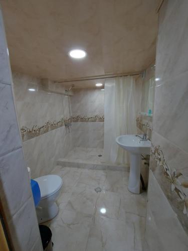 a white bathroom with a toilet and a sink at Hotel Rabat Castle in Akhaltsikhe