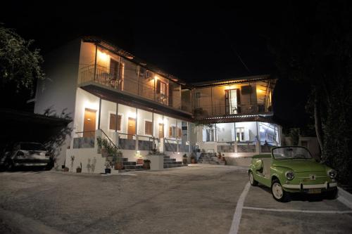 a green car parked in front of a building at night at Petros Giatras - Rooms in Zakynthos Town