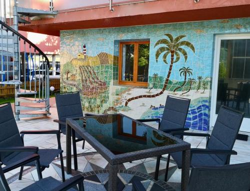 a table and chairs in front of a mosaic wall at Apartment Schwarzindien in Sankt Lorenz