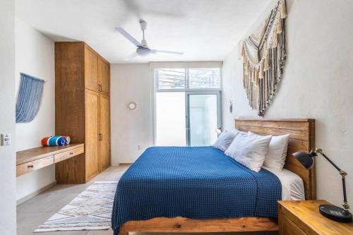 a bedroom with a blue bed with a ceiling fan at Casa Chaparra - Monterosa in Sayulita