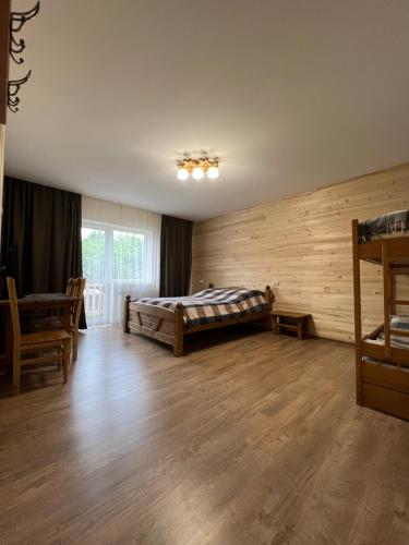 a bedroom with a bed and a wooden wall at Кам'яний двір in Mykulychyn