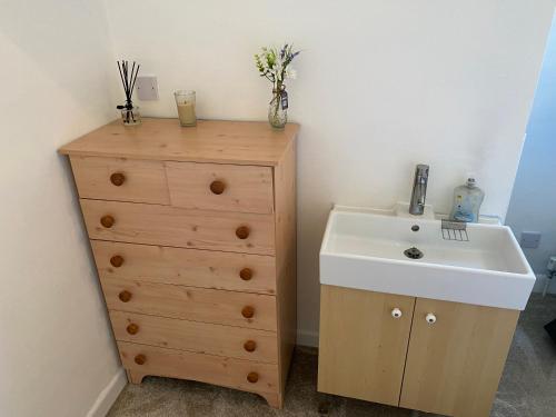 a bathroom with a sink and a wooden dresser at Spacious single and double bedroom in Southampton with free parking in Southampton