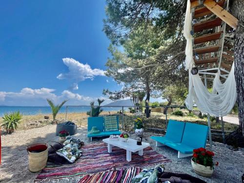 a group of blue chairs and a table on the beach at Art BeachFront Villa in Lefkada Town