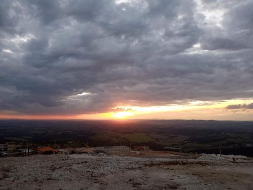 a sunset from the top of a hill with clouds at CASA TOCA FURADA in São Thomé das Letras