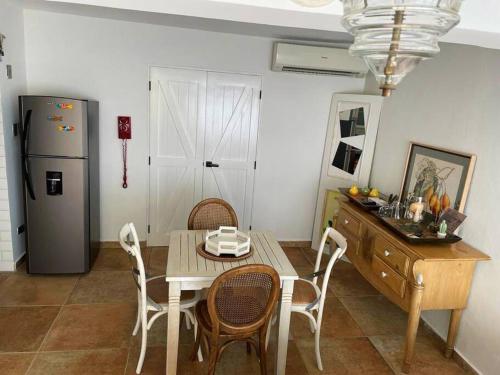 La cuisine est équipée d'une table, de chaises et d'un réfrigérateur. dans l'établissement Amazing apartment, Juan Dolio, El Bonio II- 2B, à Juan Dolio