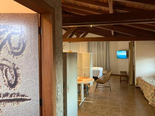 a room with a bed and a table in a room at Studios Aromas do Campeche - Floripa in Florianópolis