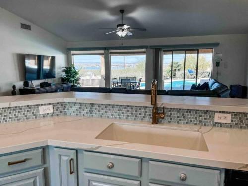 a kitchen with a sink and a living room at Villa La Isla PANORAMIC VIEWS, Outdoor Kitchen, sleeps 16 in Lake Havasu City