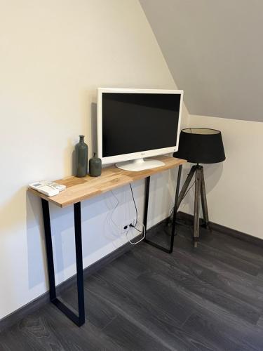 escritorio con monitor de ordenador y silla en Maison chiron en Montreuil-sur-Maine