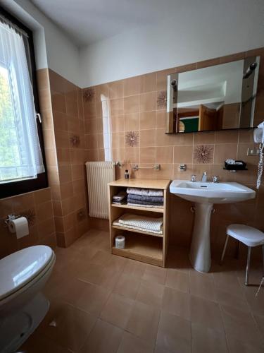 a bathroom with a sink and a toilet and a mirror at Monterovere in Albergo Monte Rovere
