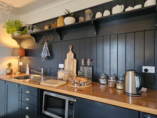 a kitchen with a counter top with a microwave at Blue Bell Cottage. Serene luxury farmstead in Lower Moutere