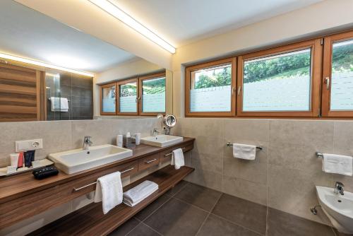 a bathroom with two sinks and two mirrors at Weingut Eichenstein in Merano