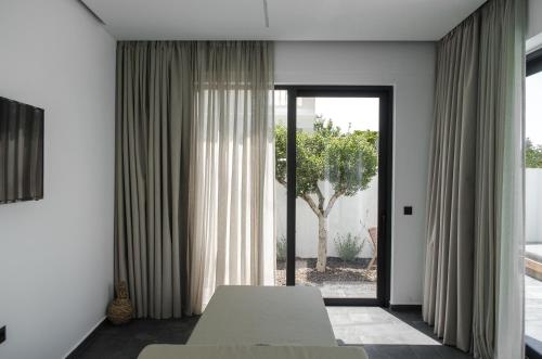 a living room with a white couch and a window at Hygge Suites in Hersonissos