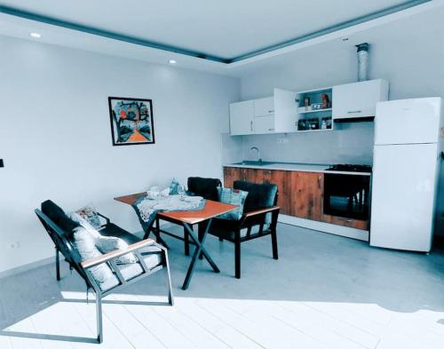 sala de estar con mesa y sillas y cocina en Delfina and Delfino Cozy Home, en Kışlabucağı