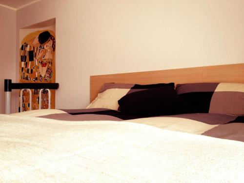 a bedroom with a large white bed with a wooden headboard at B&B Il Cortile in Vercurago
