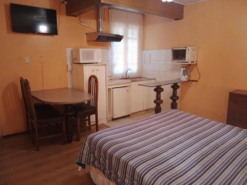 a room with a bed and a table and a kitchen at Aquamarina Apart Hotel in Viña del Mar