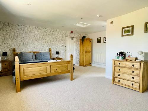 ein Schlafzimmer mit einem Bett und einer Kommode in der Unterkunft The Maltsters Country Inn in Badby