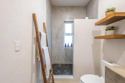 a small bathroom with a toilet and a window at Casa Quince - Monterosa in Sayulita