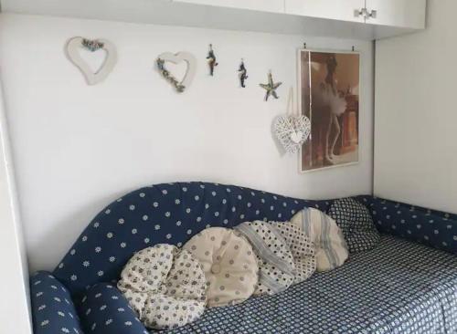 eine blaue Couch mit Kissen darauf in einem Zimmer in der Unterkunft CASA VACANZE 'LA BOUGANVILLEA' FORIO ISCHIA in Ischia
