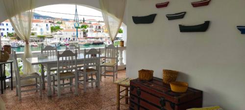 una sala da pranzo con tavolo, sedie e un porto di Anezo's Exceptional View a Spetses