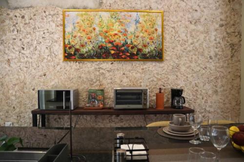 梅里達的住宿－Casa Coco，厨房墙上的画作,配有微波炉