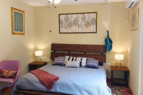 um quarto com uma cama com duas mesas e dois candeeiros em Casa Coco em Mérida