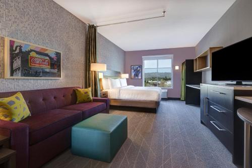 ペタルーマにあるHome2 Suites By Hilton Petalumaのソファとベッド付きのホテルルーム