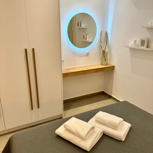 a room with a mirror and two towels on a bed at Rodanthi 4 Seasons Unique House in Tympáki