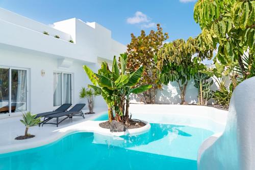 een villa met een zwembad met bomen en planten bij Villas Veaco Bahiazul with private pool in Corralejo