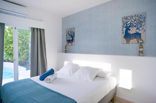 1 dormitorio con cama blanca y ventana en Villas Veaco Bahiazul with private pool, en Corralejo