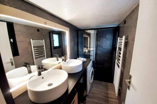 een badkamer met 2 wastafels en een grote spiegel bij Gîte 14 pers LesOursFanfarons spacieux chaleureux in Bramans