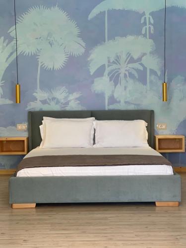ein Schlafzimmer mit einem Bett mit blauen und weißen Tapeten in der Unterkunft Vila Milo in Himarë