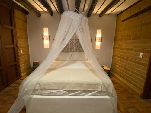 - une chambre avec un lit et une moustiquaire dans l'établissement Estancia Arboreto - Reserva Natural, à Barichara