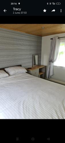 a bedroom with a white bed and a window at Glampavan in Haven Street