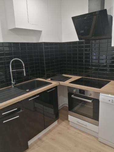 une cuisine avec un évier et une cuisinière dans l'établissement Havre de paix à 5 min de la plage, au Havre