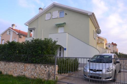 ein Haus mit einem davor geparkten Auto in der Unterkunft Apartment Malči in Čižići