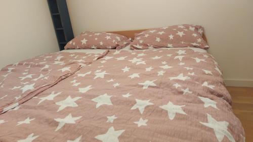 ein Bett mit einer rosa Bettdecke mit weißen Sternen darauf in der Unterkunft Apartment Malči in Čižići