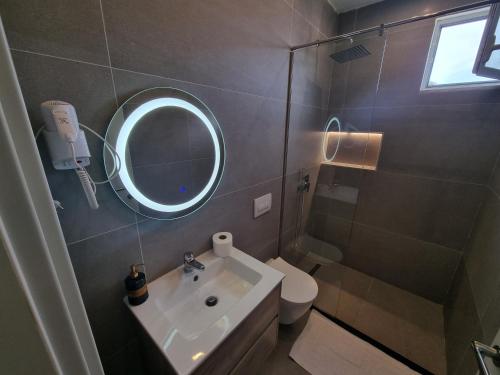 een badkamer met een wastafel, een spiegel en een toilet bij Hotel Ble Ble Vlore in Vlorë