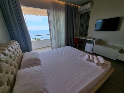 um quarto de hotel com uma cama grande e uma varanda em Hotel Ble Ble Vlore em Vlorë