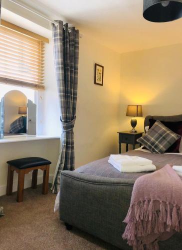 a room with two beds and a window and a mirror at Traditional Cottage in Harbour Town of Watchet in Watchet