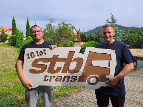 dois homens segurando uma placa que diz lado esquerdo em Stara Kuźnia em Sosnówka