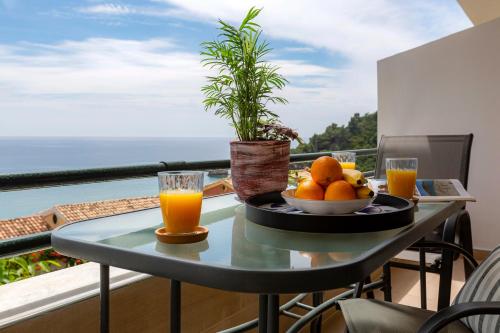 a table with a bowl of oranges and two glasses of orange juice at sofia's apart 4u (114) in Glyfada
