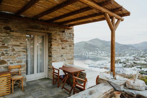 a patio with a table and chairs and a view at Heliopetra Punta in Ios Chora