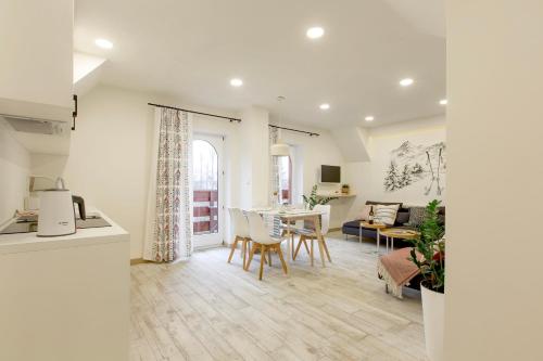 a kitchen and living room with a table and chairs at Willa Kosówka - Apartamenty i pokoje in Zakopane