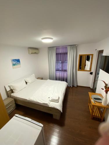 a bedroom with a white bed and a window at N&D Villa in Eforie Sud
