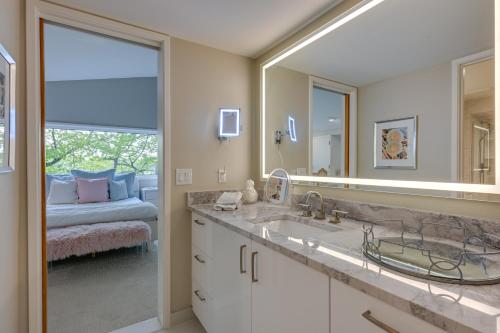 een badkamer met een wastafel en een grote spiegel bij Immaculate, High-End Howell Villa on Pardee Lake! in Howell