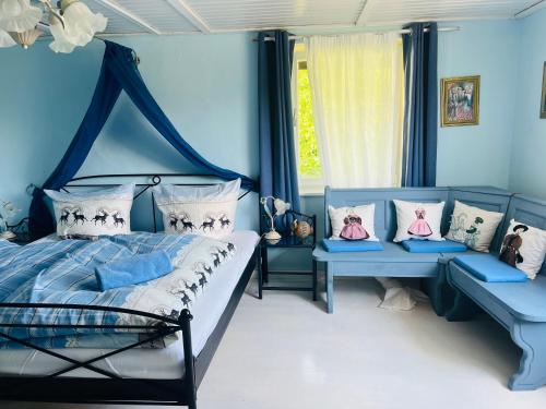 a blue bedroom with a bed and two benches at Charming historical farmhouse in Finning