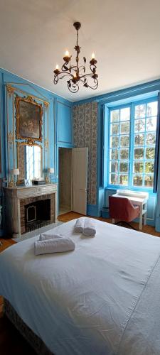 une chambre avec un grand lit blanc avec des murs bleus dans l'établissement Chateau de la Grand'Maison, à Bellême